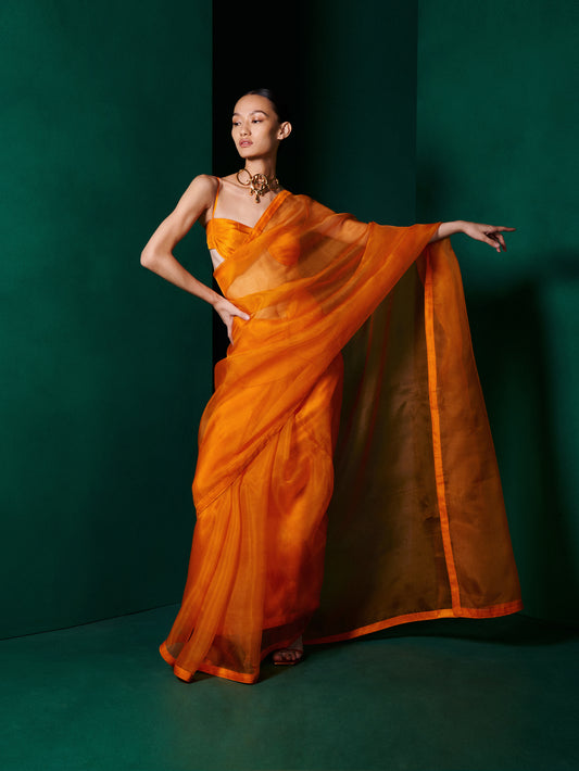 orange saree dress Kerei is a well structured, pre-stitched saree in a beautiful orange shade. The blouse is an entirely embellished sexy number, and the saree has an intricately crafted pallu with our signature embroidery
